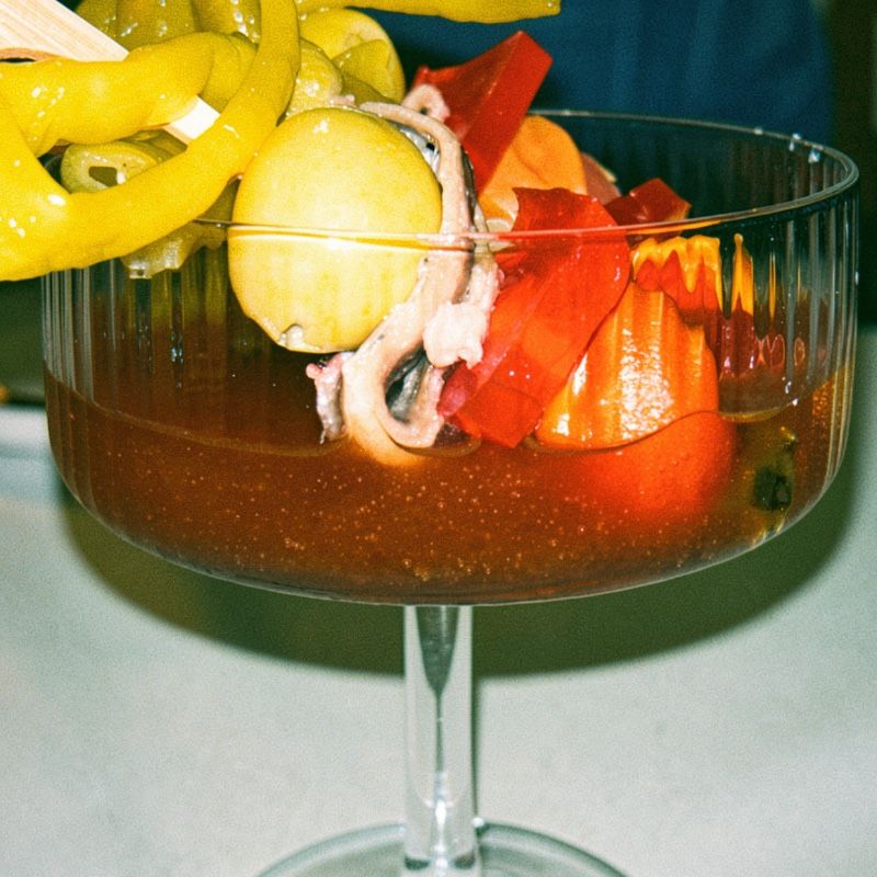 Foto de Gilda de tomate confitado, pilates, gel de aperol y queso azul