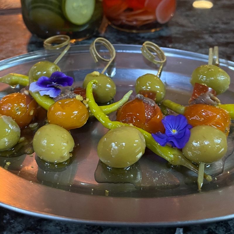 Foto de Gilda de tomate confitado, piparra, gel de aperol y anchoa